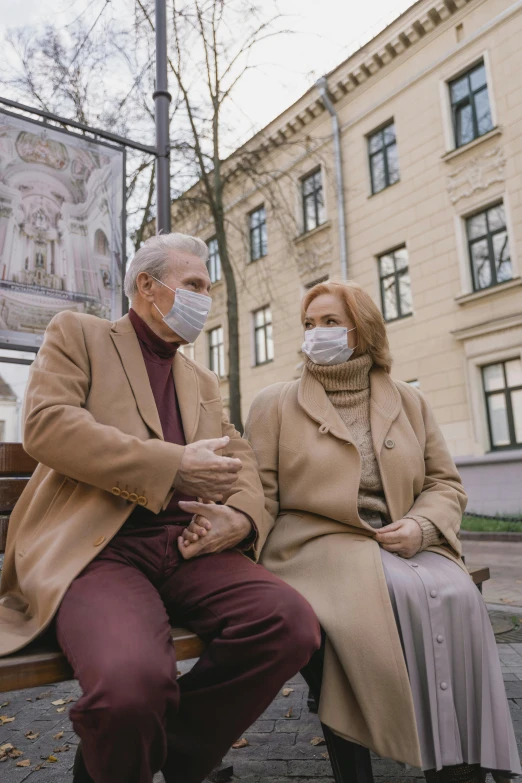 a man and a woman sitting on a bench, people are wearing masks, brown, old man, gray