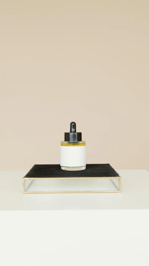 a bottle of liquid sitting on top of a table, inspired by Agnes Martin, minimalism, black resin, honey, thumbnail, n - 4