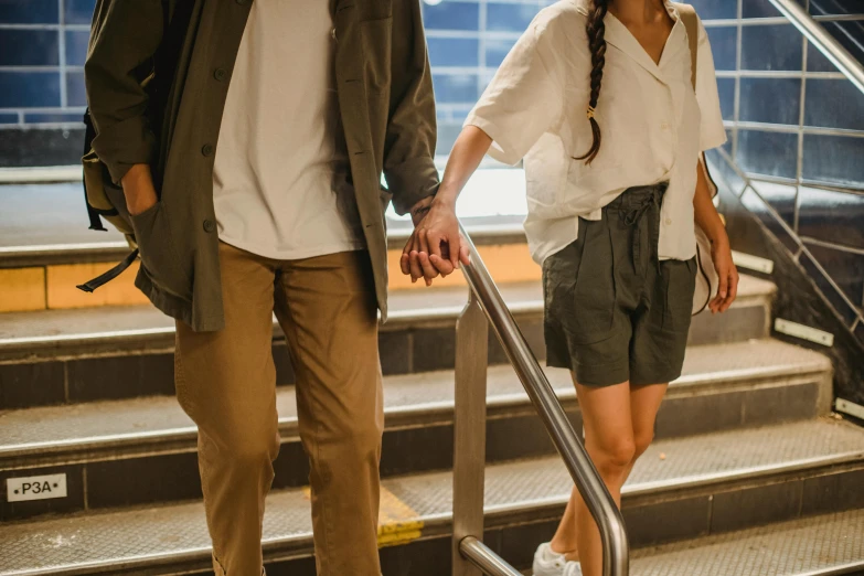 a man and a woman walking down a flight of stairs, trending on pexels, wearing a linen shirt, holding hands, in a subway, thigh gap