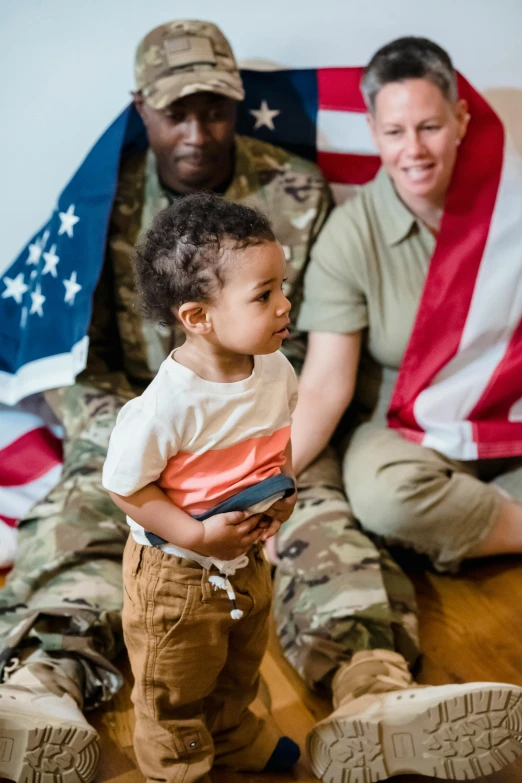 a man and a little boy sitting on the floor in front of an american flag, military-grade, square, gen z, toddler