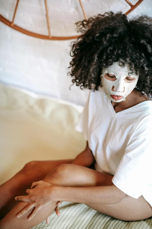 a woman with white face paint sitting on a bed, trending on pexels, renaissance, brown skin like soil, eucalyptus, ski mask, pleasing