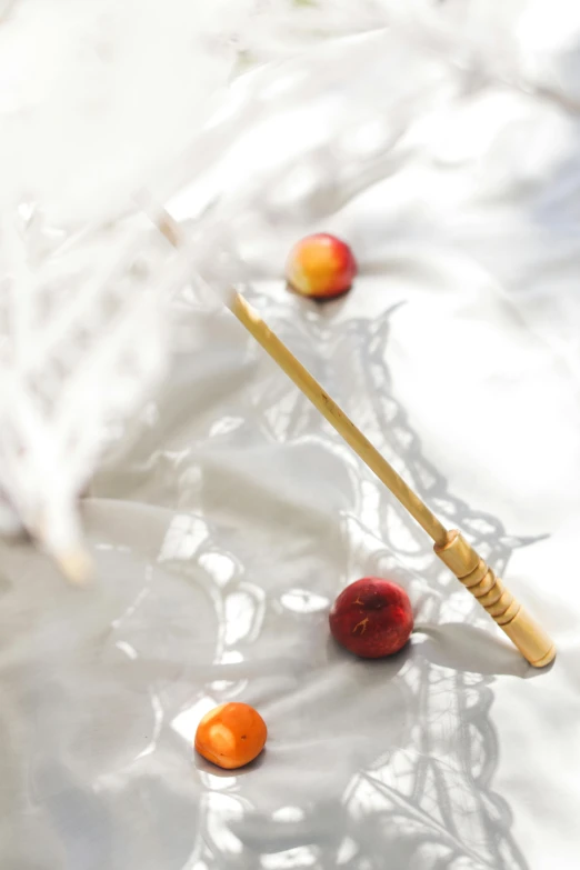 a couple of apples sitting on top of a white sheet, by Fuller Potter, unsplash, process art, long trunk holding a wand, gold, scattered props, japanese collection product