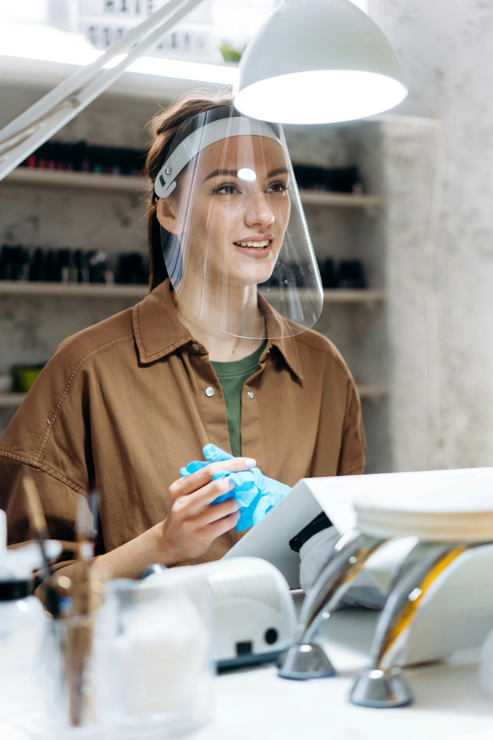 a woman wearing a face shield in a beauty salon, a portrait, shutterstock, arbeitsrat für kunst, sitting on a lab table, smiling, thumbnail, small in size