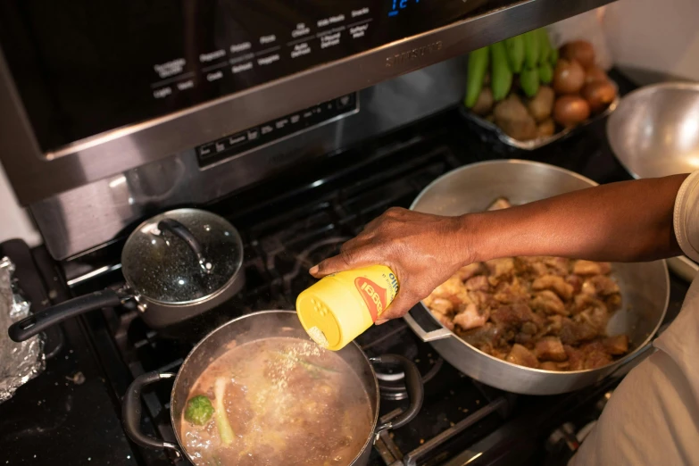 a close up of a person cooking food on a stove, lady using yellow dress, essence, thumbnail, oily sheen