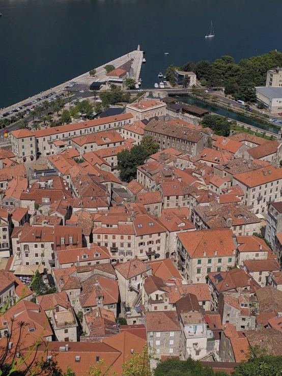 an aerial view of a town next to a body of water, by Jan Rustem, pexels contest winner, happening, square, tiled roofs, split near the left, highly detailed textured 8k