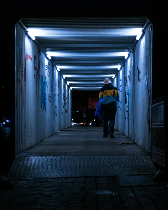 a couple of people that are standing in a tunnel, by Niko Henrichon, streetlights, non-binary, trending photo, cold blue light