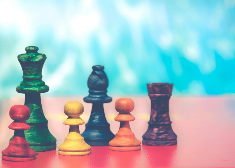 a group of chess pieces sitting on top of a table, a cartoon, by Carey Morris, unsplash, bright vivid color hues:1, lgbtq, profile picture 1024px, vintage colours