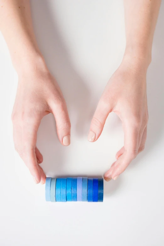 a person holding a roll of toilet paper in their hands, inspired by Larry Zox, process art, lapis lazuli gradients, bangles, on white background, dna experiment