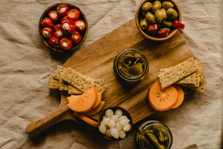 a wooden cutting board topped with cheese and olives, by Carey Morris, pexels, jars, avatar image, pickle, background image