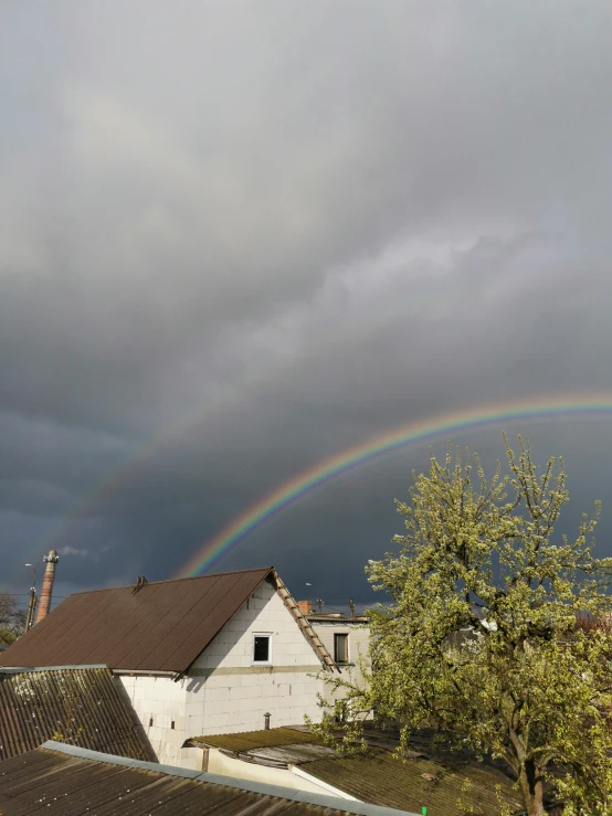 a rainbow is in the sky over a house, by Anato Finnstark, slide show, dasha taran, journalism photo, overcast