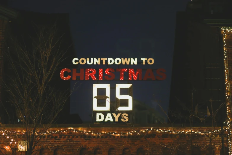 a sign on the side of a building that says countdown to christmas 35 days, by Julia Pishtar, pexels contest winner, happening, 2 5 6 x 2 5 6 pixels, night time, rinko kawauchi, brown