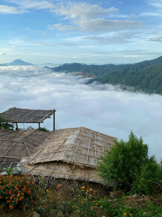 a group of huts sitting on top of a lush green hillside, pexels contest winner, sumatraism, view above the clouds, panorama distant view, bird\'s eye view, taken on iphone 1 3 pro