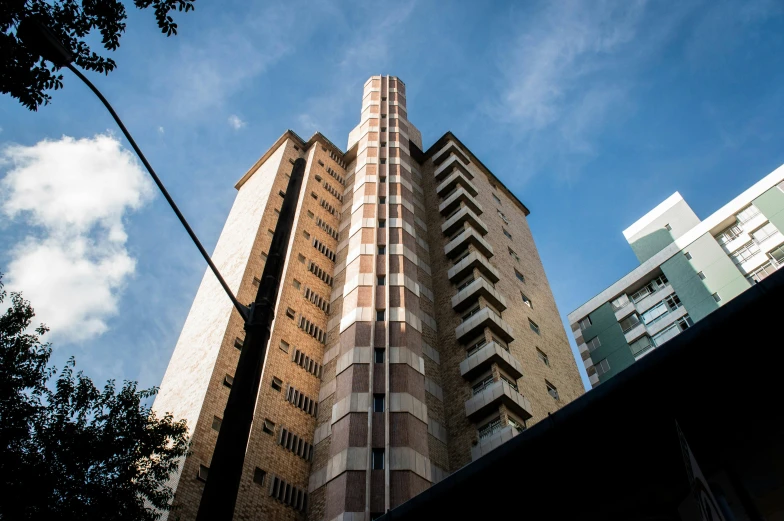 a tall building sitting in the middle of a city, by Lee Loughridge, unsplash, brutalism, in chippendale sydney, taken in 1 9 9 7, ten flats, brown