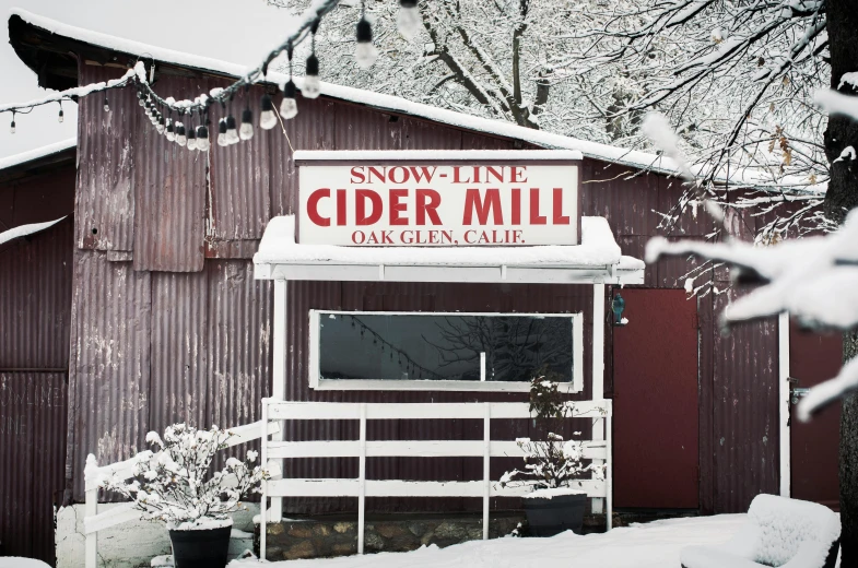 a sign that is on the side of a building, folk art, light snowfall, cider - man, mill, outdoor fine art photography