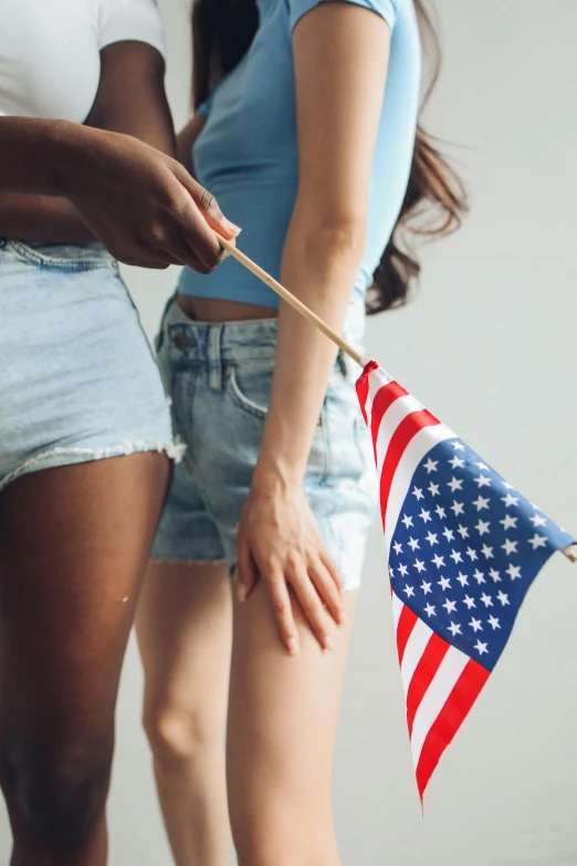 two women standing next to each other holding an american flag, trending on tumblr, jean shorts, essence, holding each other hands, 15081959 21121991 01012000 4k