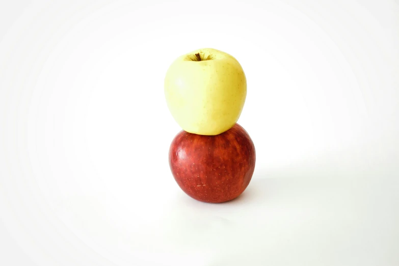 two apples stacked on top of each other, inspired by Sarah Lucas, minimalism, yellow and red, medium - shot, one object, medium angle