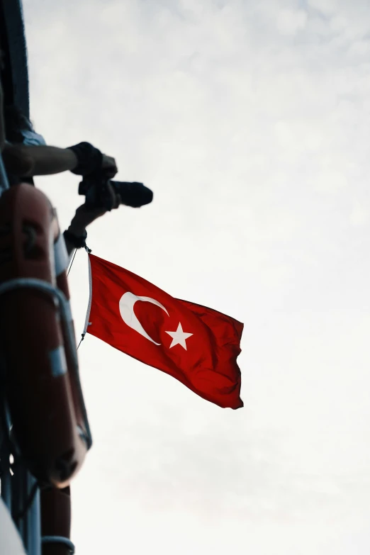 a red and white flag hanging from the side of a building, by Nevin Çokay, hurufiyya, slide show, multiple stories, turkey, on ship