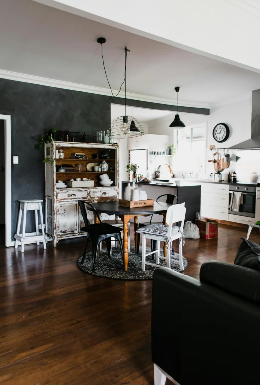 a black couch sitting in a living room next to a kitchen, pexels contest winner, country style, manly design, chefs table, studio photo