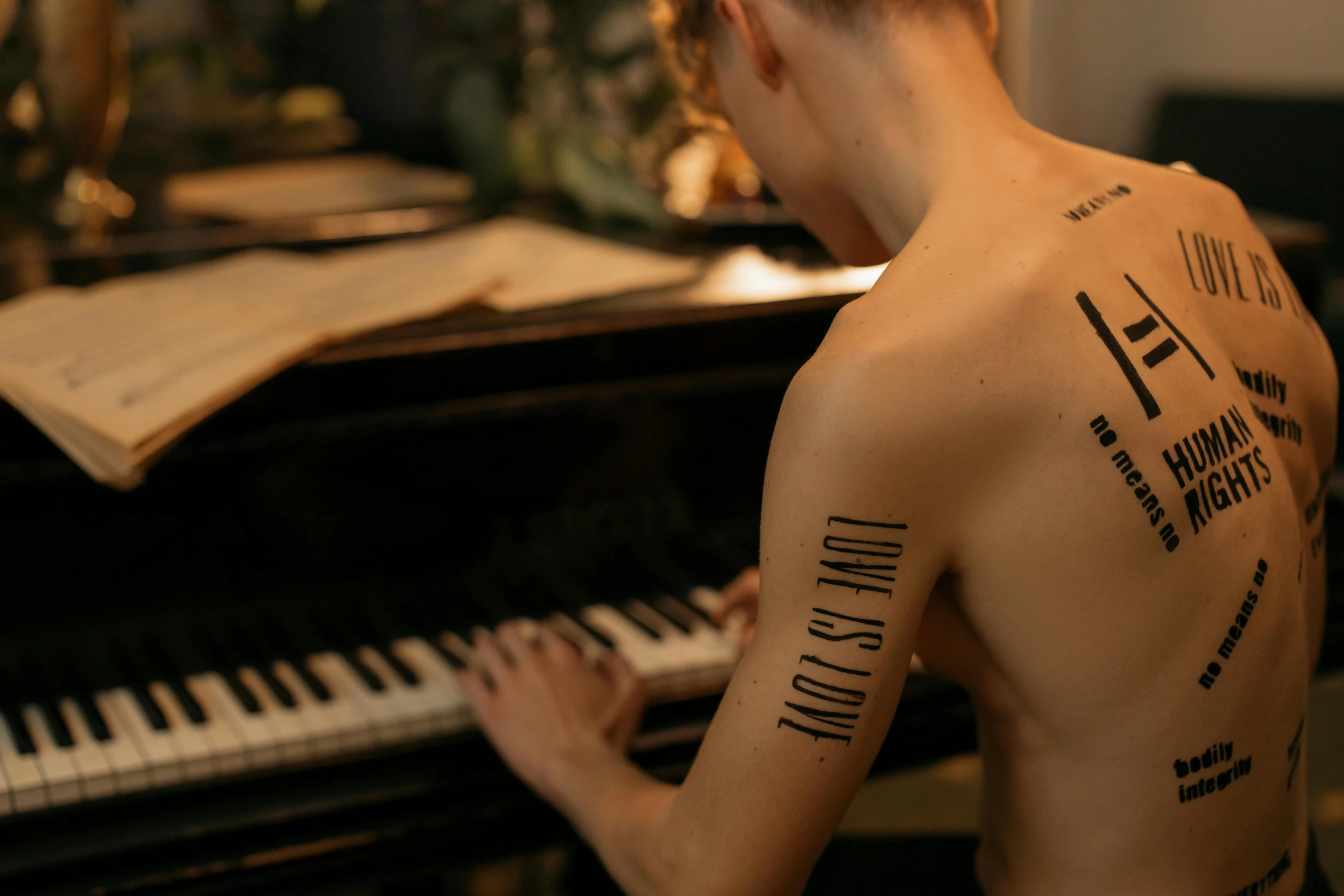 a man with a tattoo on his back playing a piano, a tattoo, trending on pexels, non binary model, made of notation, woman, rib cage