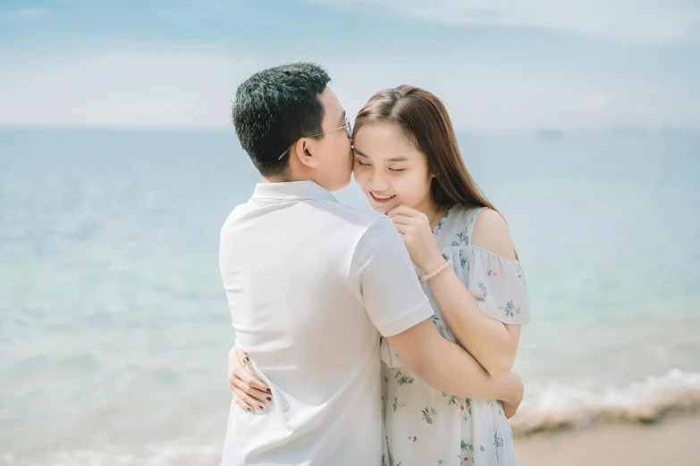 a man and woman standing next to each other on a beach, pexels contest winner, asian girl, sweet hugs, avatar image, yanjun chengt