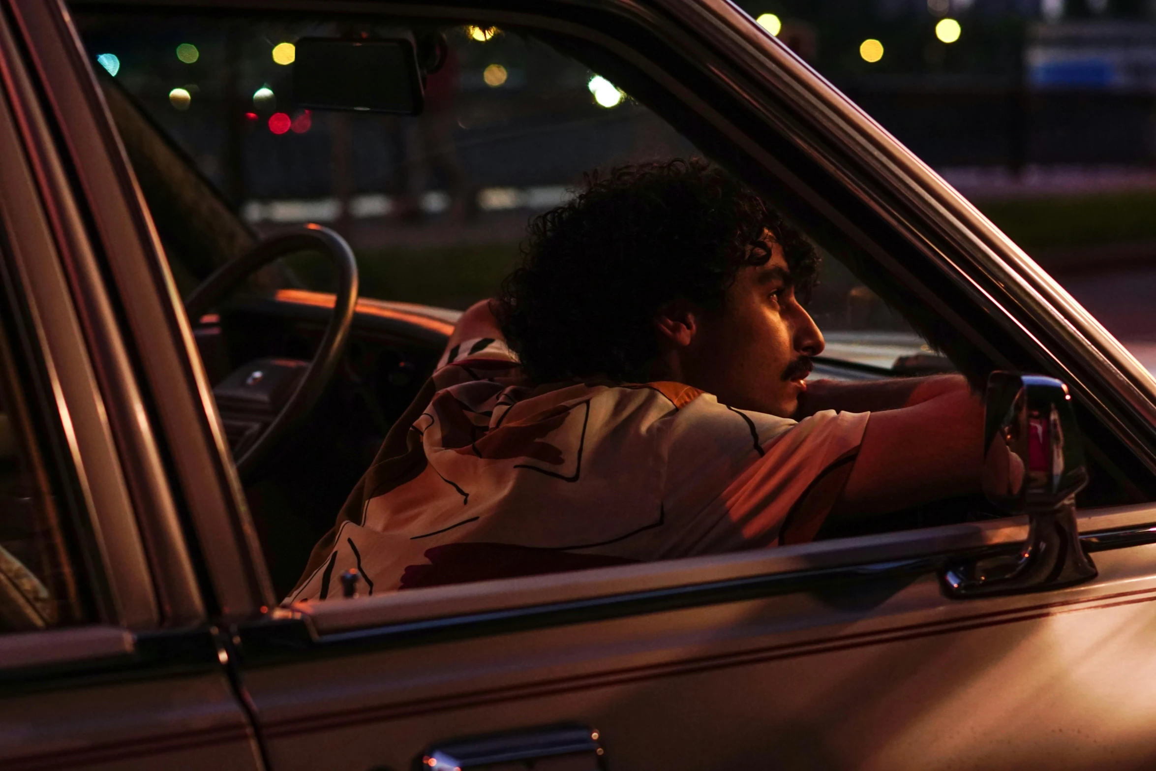 a man sitting in the passenger seat of a car, inspired by Nan Goldin, pexels, serial art, imaan hammam, still from riverdale, warm summer nights, promotional image