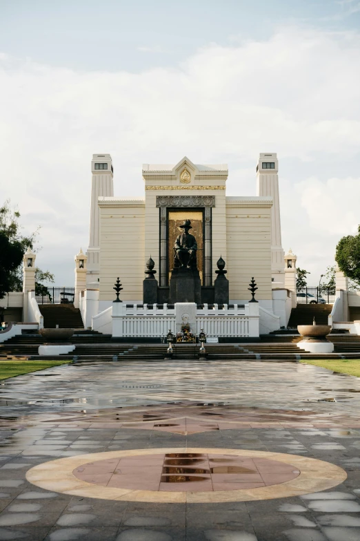 a large white building sitting on top of a lush green field, a statue, inspired by Carel Willink, neoclassicism, bangkok townsquare, gold throne, rain lit, masonic lodge