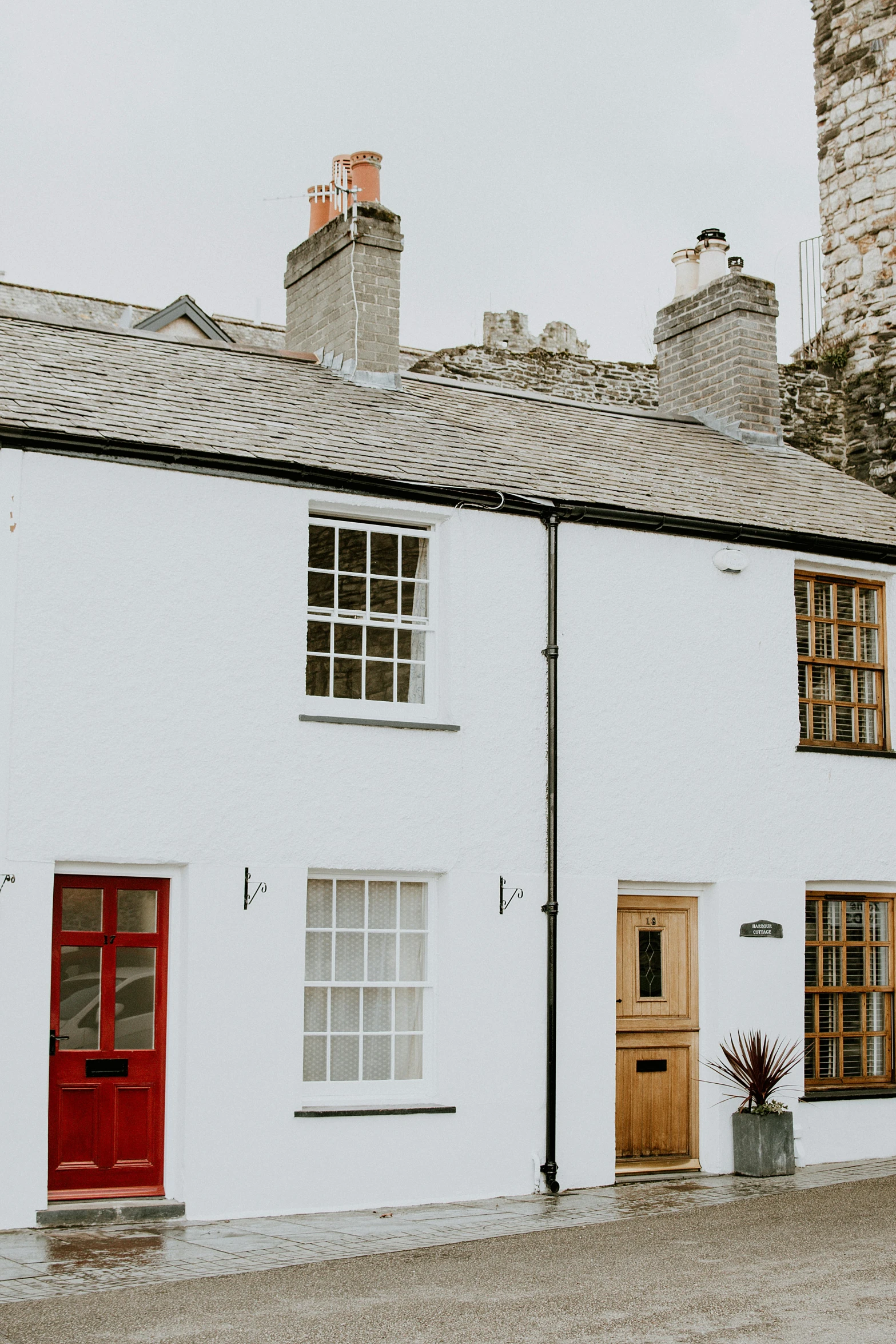 a white house with a red door and windows, by IAN SPRIGGS, pexels contest winner, arts and crafts movement, cornwall, narrow and winding cozy streets, thumbnail, black