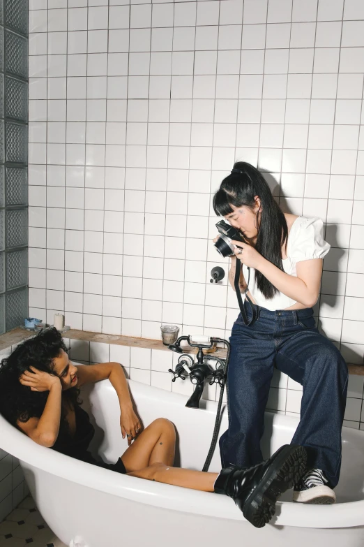 a woman taking a picture of another woman in a bathtub, an album cover, unsplash, sui ishida with black hair, film shooting, set photo, studio photo