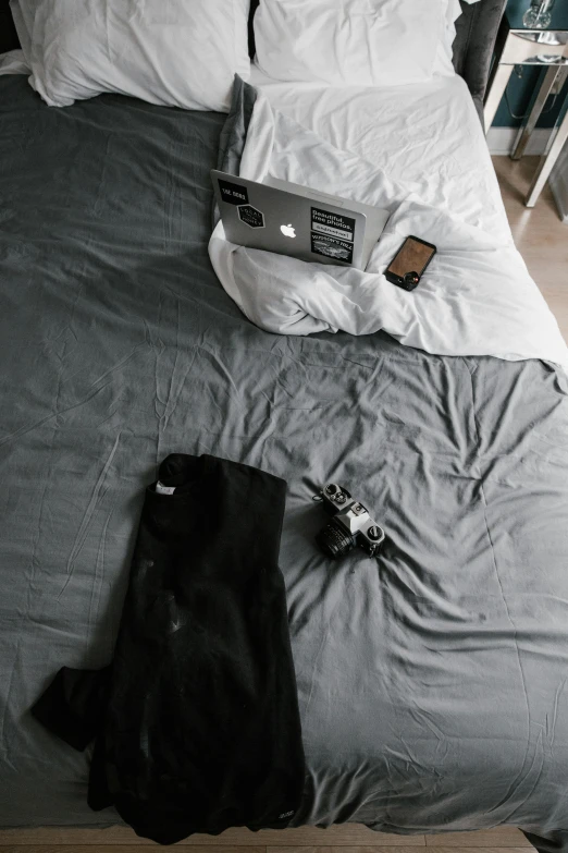 a bed with a laptop sitting on top of it, by Andries Stock, unsplash contest winner, trending on r/streetwear, high angle camera, iphone picture, grey