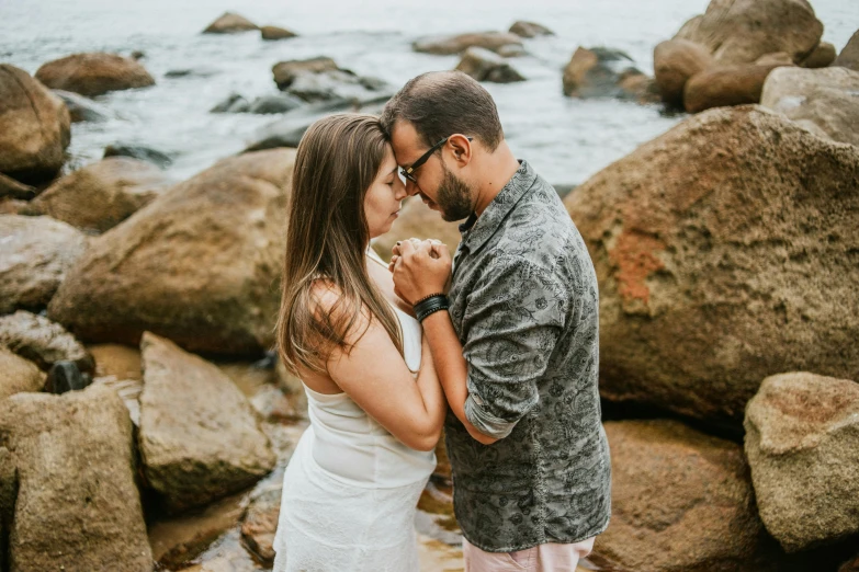 a man and woman standing next to each other on a rocky beach, pexels contest winner, renaissance, lovely kiss, avatar image, brazilian, high details photo