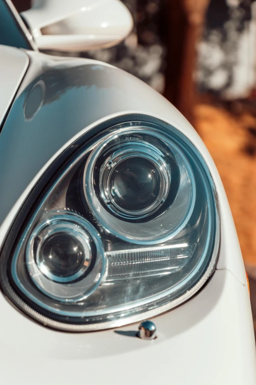 a close up of the headlight of a white car, inspired by Harry Haenigsen, pexels contest winner, photorealism, smooth oval head, tail lights, perfect crisp sunlight, porche