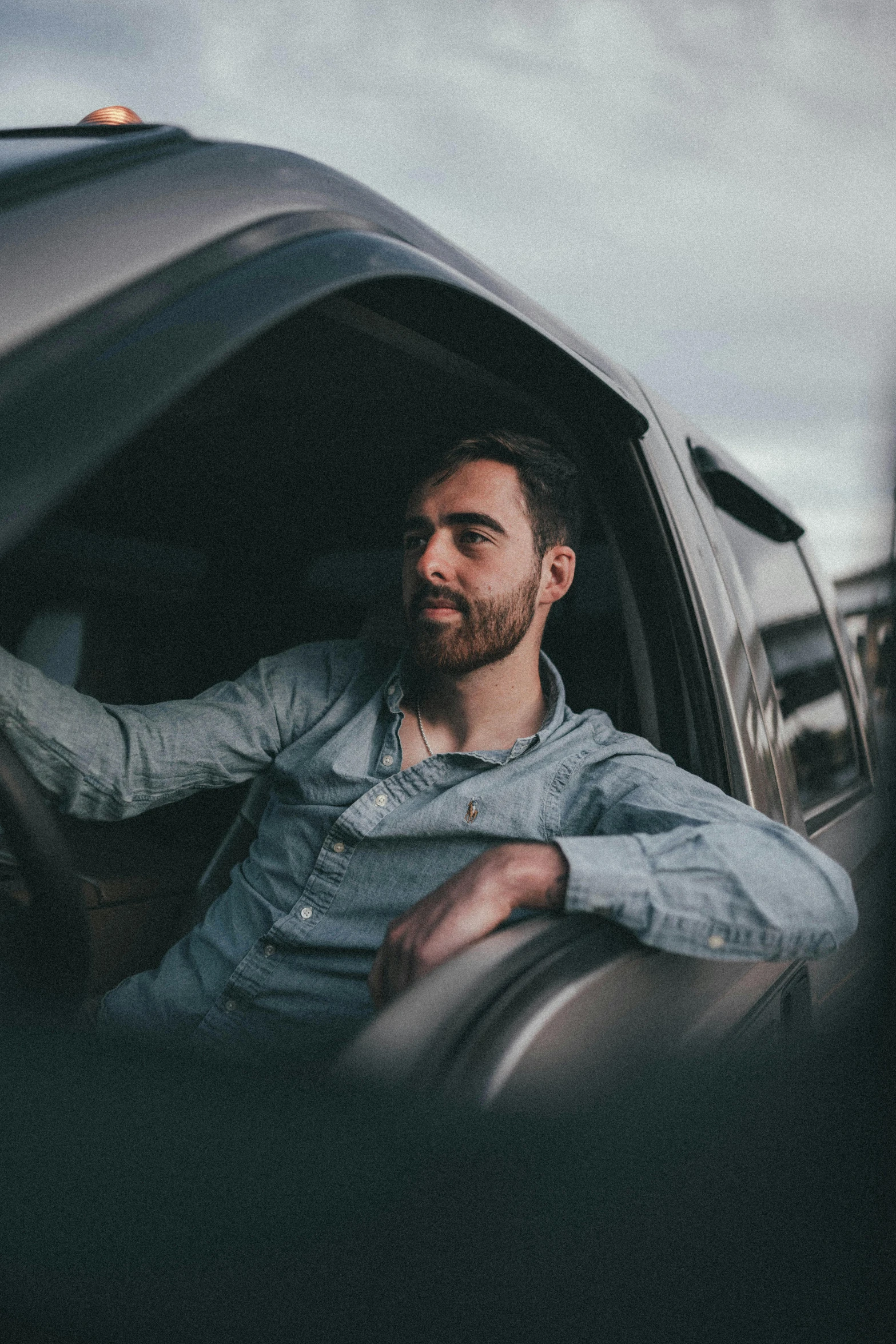 a man sitting in the driver's seat of a car, pexels contest winner, very attractive man with beard, jay bauman, discord profile picture, resting