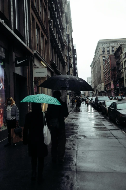 a couple of people walking down a street holding umbrellas, a colorized photo, inspired by Elsa Bleda, trending on unsplash, photorealism, manhattan, trending on vsco, ominous, street of teal stone