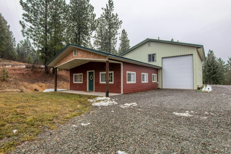 a house sitting on top of a gravel field, garage, evergreen valley, profile image