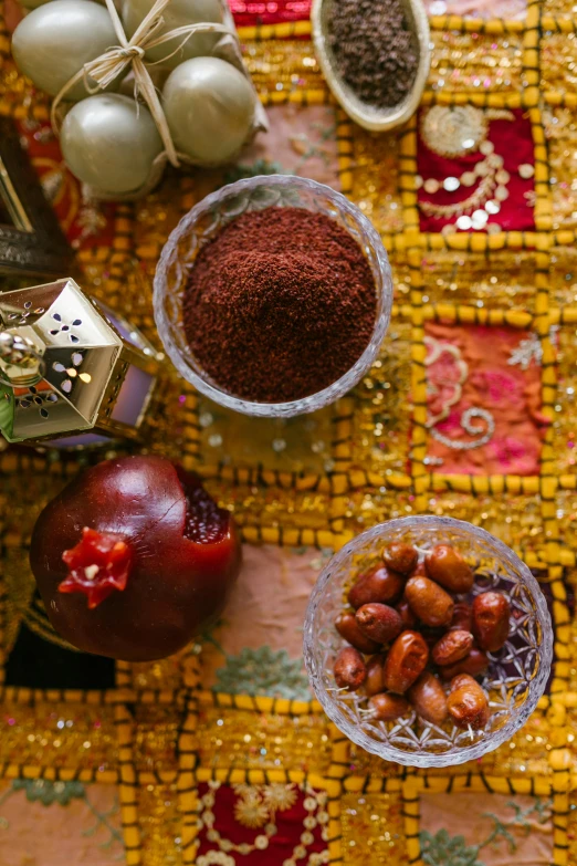 a table topped with bowls of different types of food, by Julia Pishtar, hurufiyya, red and gold cloth, chocolate, medium detail, arab inspired