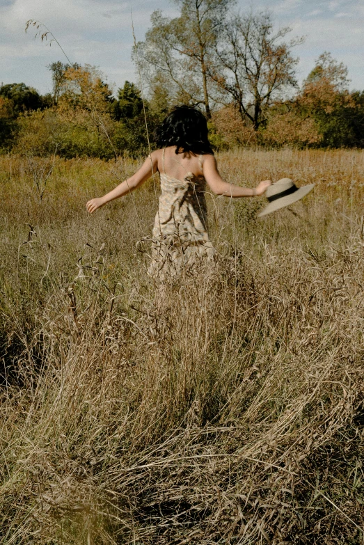 a woman standing in a field holding a knife, inspired by Andrew Wyeth, unsplash, sundress, slide show, twirling, ignant