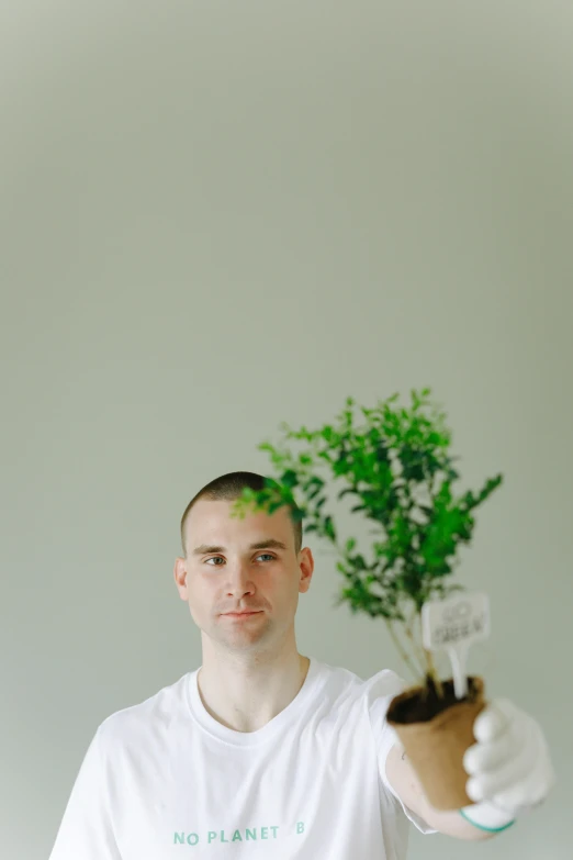 a man holding a plant in one hand and a light bulb in the other, an album cover, by Attila Meszlenyi, unsplash, buzz cut, bryan lee o'malley, mid length portrait photograph, sprouting