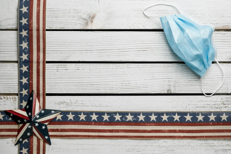 a blue face mask sitting on top of an american flag, pexels contest winner, a wooden, ribbon, panels, fourth of july