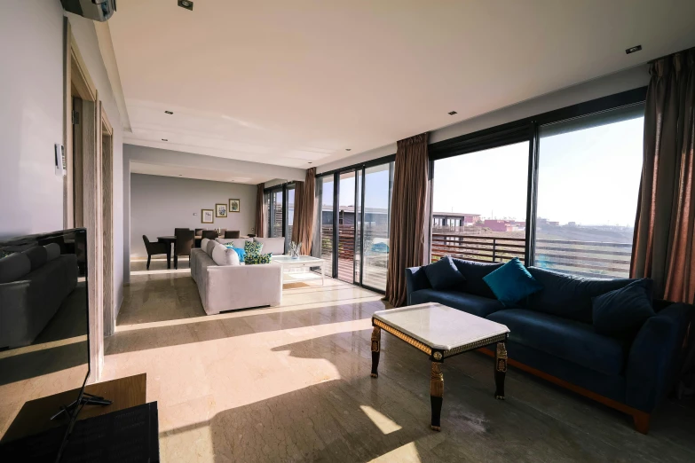 a living room filled with furniture and a flat screen tv, unsplash, light and space, futuristic marrakech morocco, floor - to - ceiling windows, panorama view, full daylight