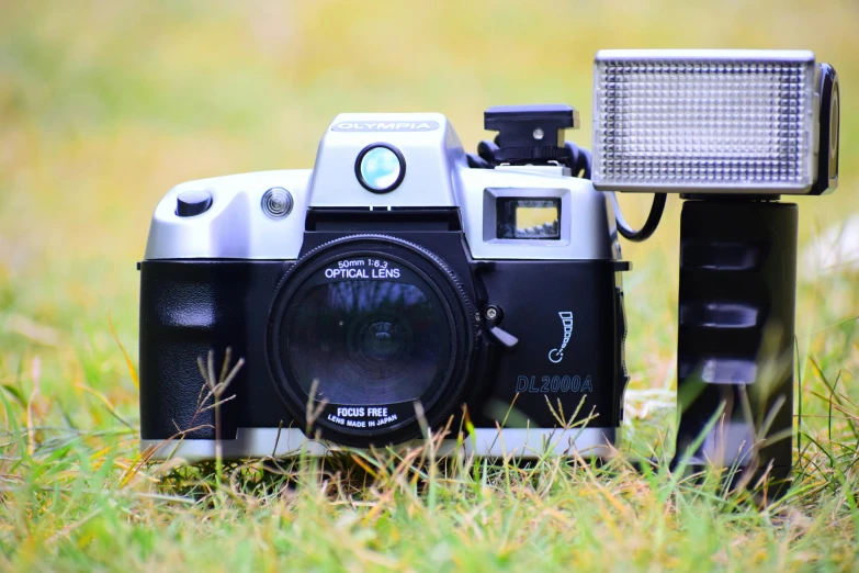 a camera that is sitting in the grass, by Adam Marczyński, unsplash, photorealism, fujicolor with flash, 80s photo, medium format, silver nitrate photography