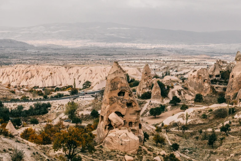 the landscape of cappadin rock formations in cappadin national park, cappadin, pexels contest winner, overlooking a valley with trees, mud and brick houses, 90s photo, asymmetrical spires