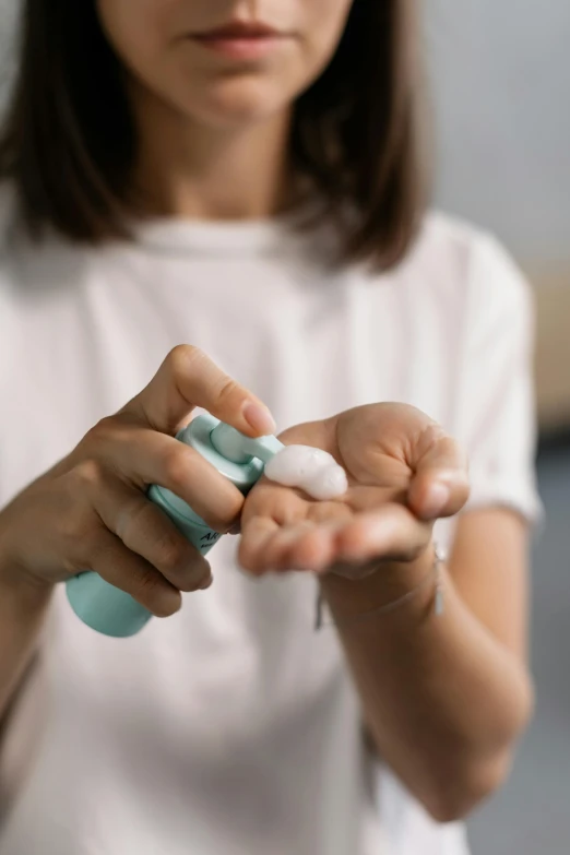 a close up of a person holding a toothbrush, holding a bottle, cream, puffy, petite