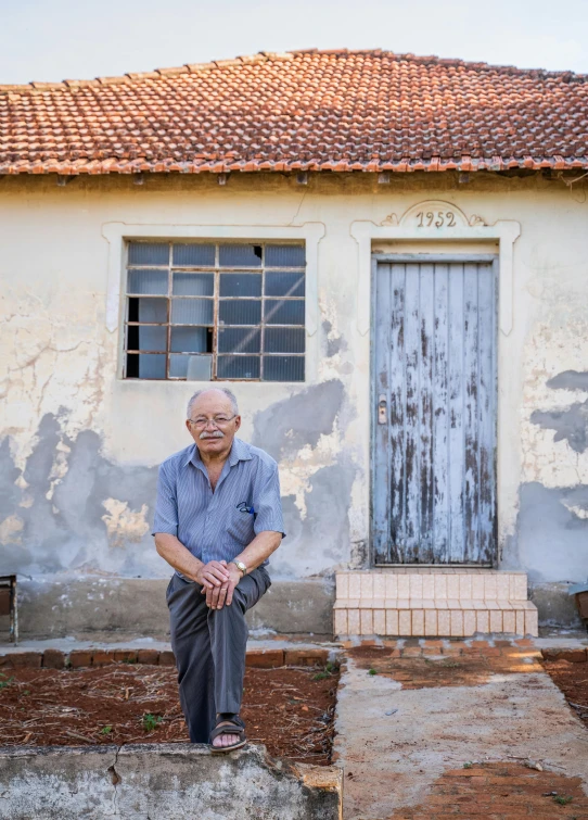 a man sitting on steps in front of a house, by Joze Ciuha, president of brazil, qi sheng luo, portrait image