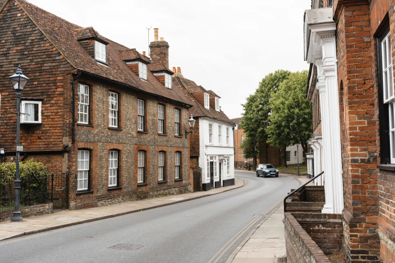 a street with a car parked on the side of it, inspired by Richmond Barthé, pexels contest winner, arts and crafts movement, old village in the distance, jane austen, stathmore 2 0 0, architectural digest