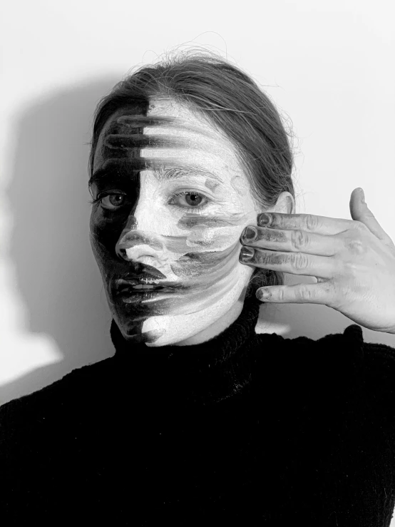 a black and white photo of a woman with white paint on her face, a black and white photo, inspired by Anna Füssli, hands shielding face, half and half, taken in the late 2000s, mandy jurgens golden ratio