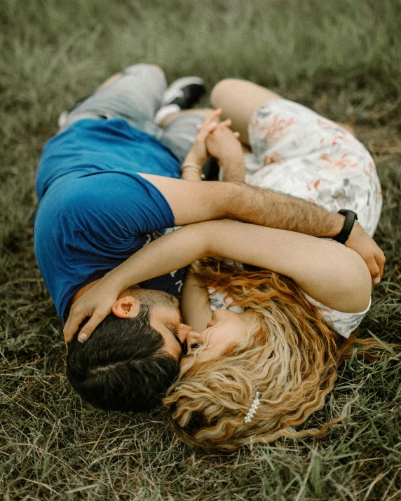 a man and a woman laying in the grass, by Lucia Peka, pexels contest winner, hugging, gif, profile image, lgbtq