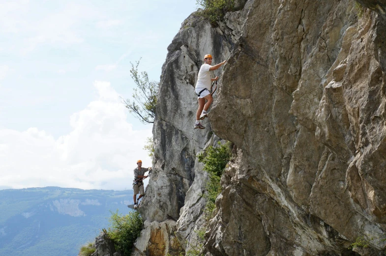 a group of people climbing up the side of a mountain, st cirq lapopie, avatar image