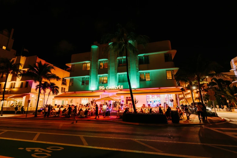 a group of people walking down a street at night, palms and miami buildings, art deco architecture, beaches, green neon