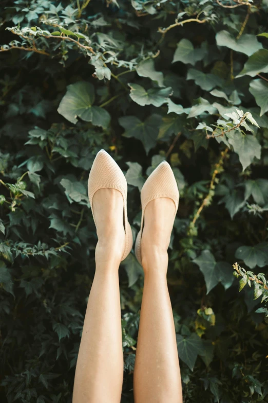 a close up of a person's legs in high heels, trending on unsplash, sitting on a leaf, beige mist, top down angle, pointè pose