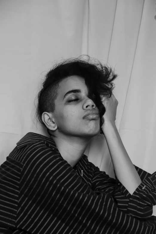 a black and white photo of a woman brushing her hair, by Alexis Grimou, genderless, imaan hammam, shaved sides, laying down